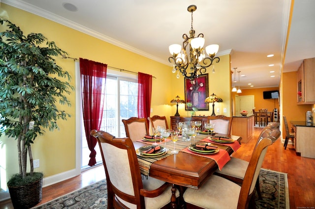 dining space with ornamental molding, a chandelier, and hardwood / wood-style flooring