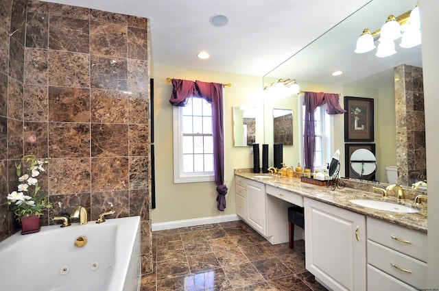 bathroom with a washtub, toilet, and vanity