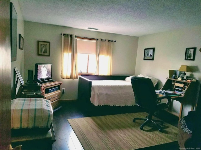 bedroom with dark wood-type flooring and a textured ceiling