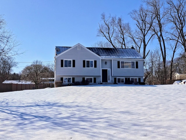 raised ranch featuring fence and a chimney