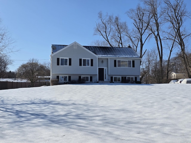 split foyer home with fence and a chimney