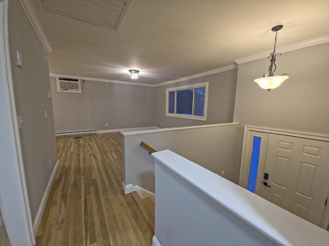 hallway with crown molding, baseboard heating, an upstairs landing, wood finished floors, and baseboards