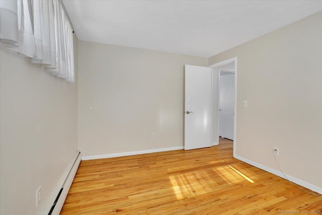 unfurnished room featuring light hardwood / wood-style flooring and a baseboard radiator