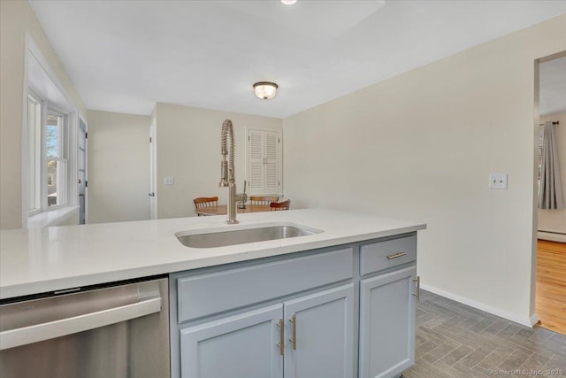 kitchen with gray cabinets, sink, and stainless steel dishwasher