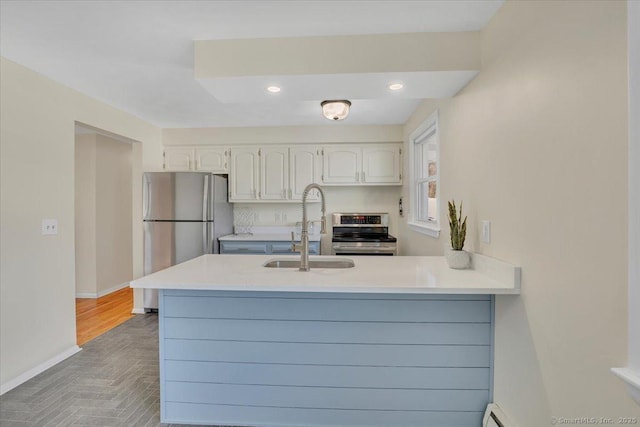 kitchen featuring white cabinetry, sink, kitchen peninsula, and appliances with stainless steel finishes