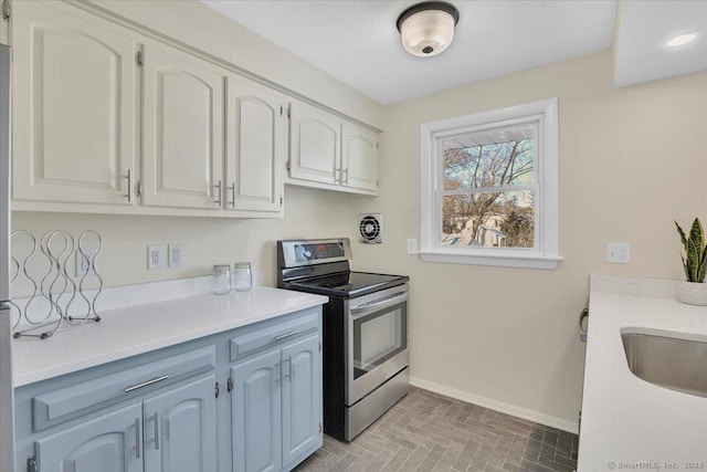 kitchen featuring white cabinetry, stainless steel electric range oven, and sink