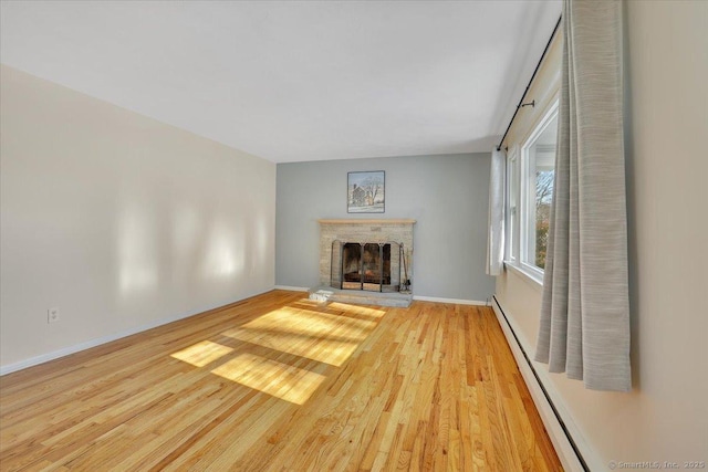 unfurnished living room featuring light hardwood / wood-style flooring and a baseboard heating unit