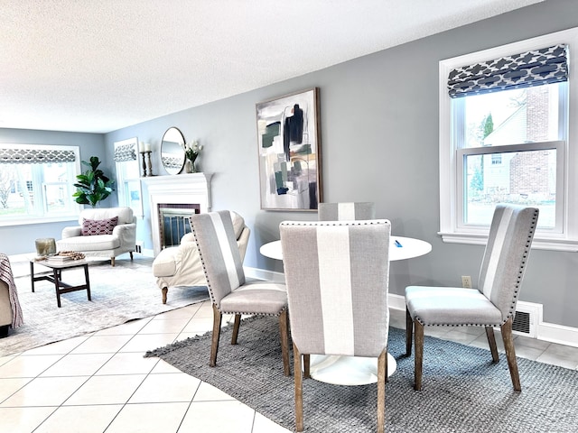 tiled dining room with a wealth of natural light and a textured ceiling