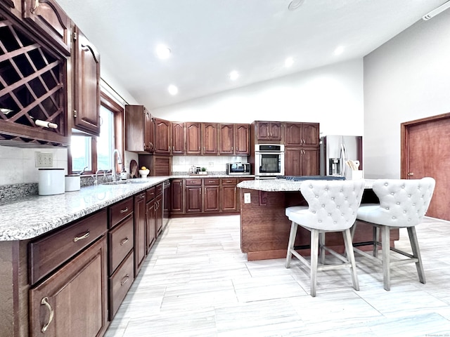 kitchen with a kitchen island, decorative backsplash, stainless steel appliances, and sink