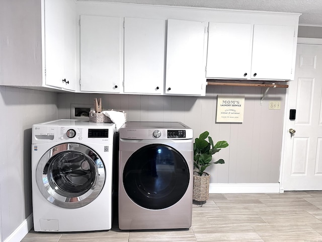 laundry area with washing machine and dryer, crown molding, light wood-type flooring, a textured ceiling, and cabinets