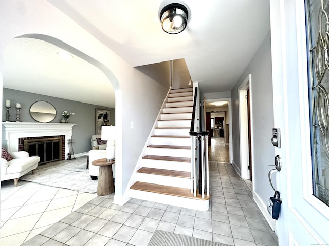 tiled entryway with a brick fireplace