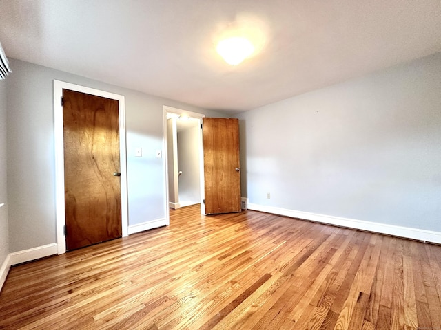 unfurnished bedroom with light wood-type flooring and a closet