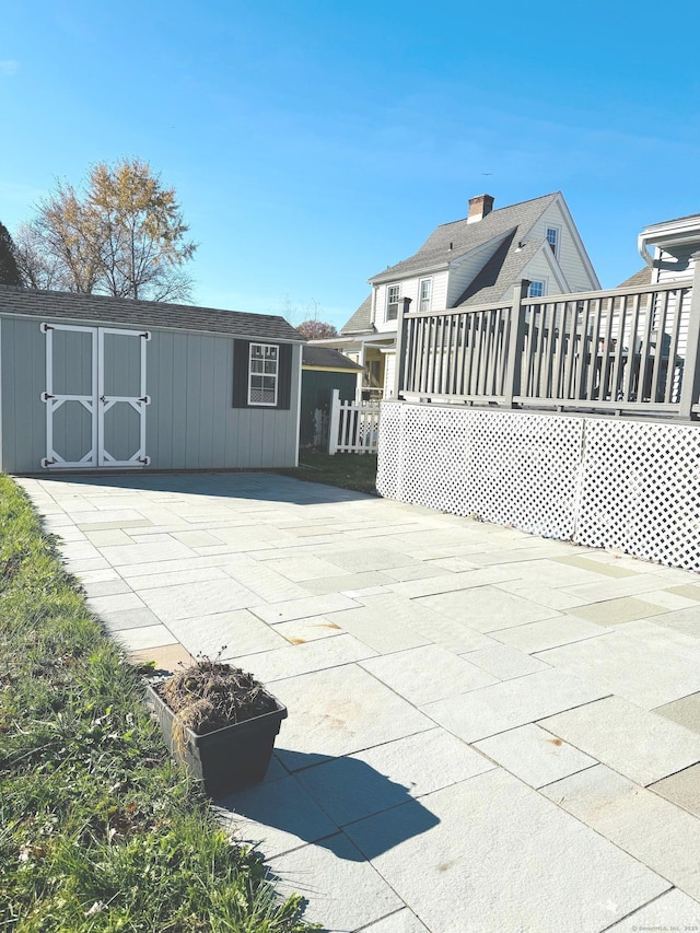 view of patio / terrace featuring a storage shed and a deck