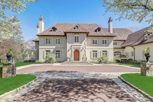4 Cowdray Park Dr, Greenwich, CT 06831 - french country style house with curved driveway, a chimney, and stucco siding
