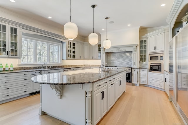 4 Cowdray Park Dr, Greenwich, CT 06831 - kitchen featuring light wood finished floors, stainless steel appliances, an island with sink, and ornamental molding