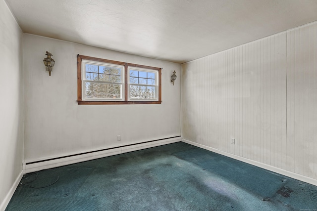 carpeted spare room featuring a baseboard heating unit