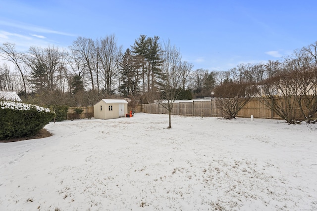 yard covered in snow with a storage unit