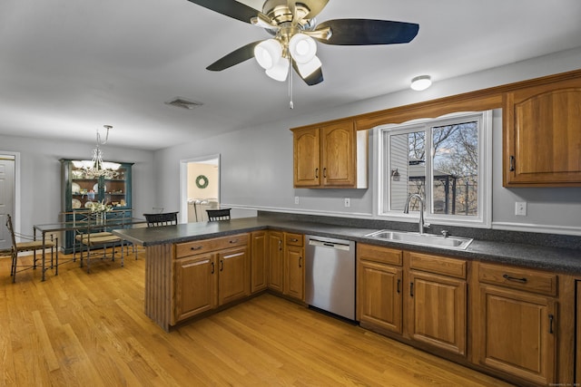 kitchen featuring light hardwood / wood-style floors, kitchen peninsula, decorative light fixtures, stainless steel dishwasher, and sink