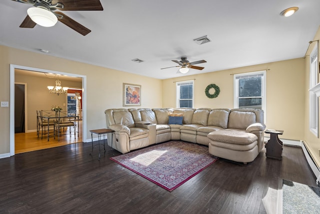 living room featuring ceiling fan with notable chandelier and dark wood-type flooring