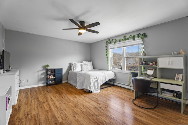 bedroom with ceiling fan, baseboard heating, and light hardwood / wood-style flooring