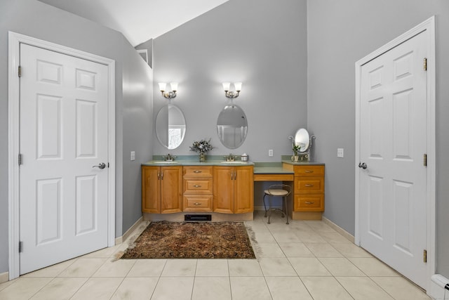 bathroom with lofted ceiling, vanity, and tile patterned flooring