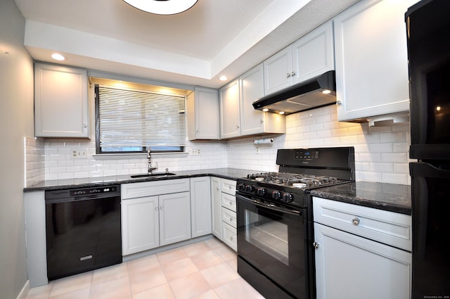 kitchen featuring sink, black appliances, dark stone counters, and white cabinets