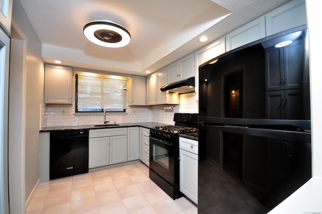 kitchen with sink, dark stone countertops, white cabinets, backsplash, and black appliances