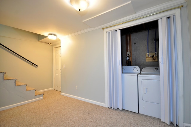 basement with light carpet, ornamental molding, and washing machine and dryer