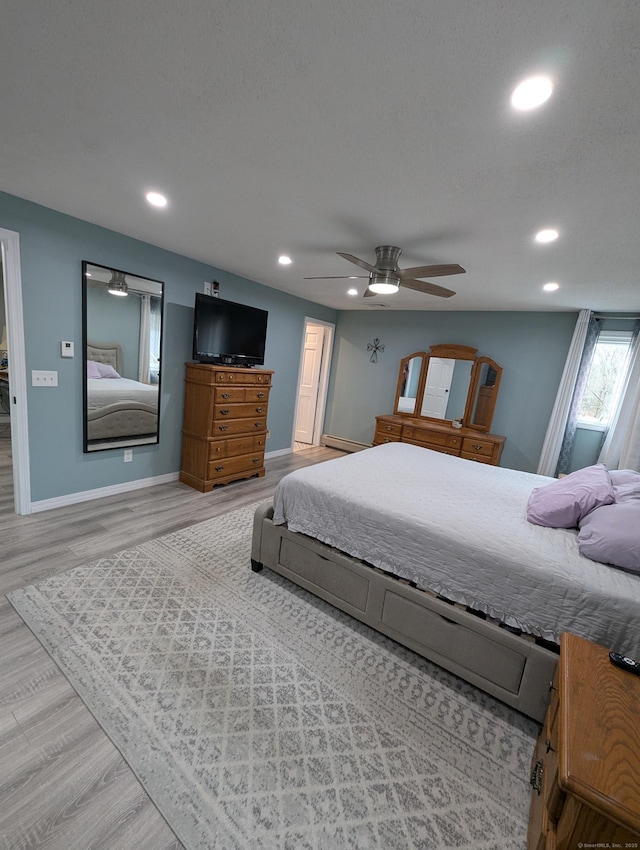 bedroom featuring ceiling fan, a baseboard radiator, and hardwood / wood-style floors