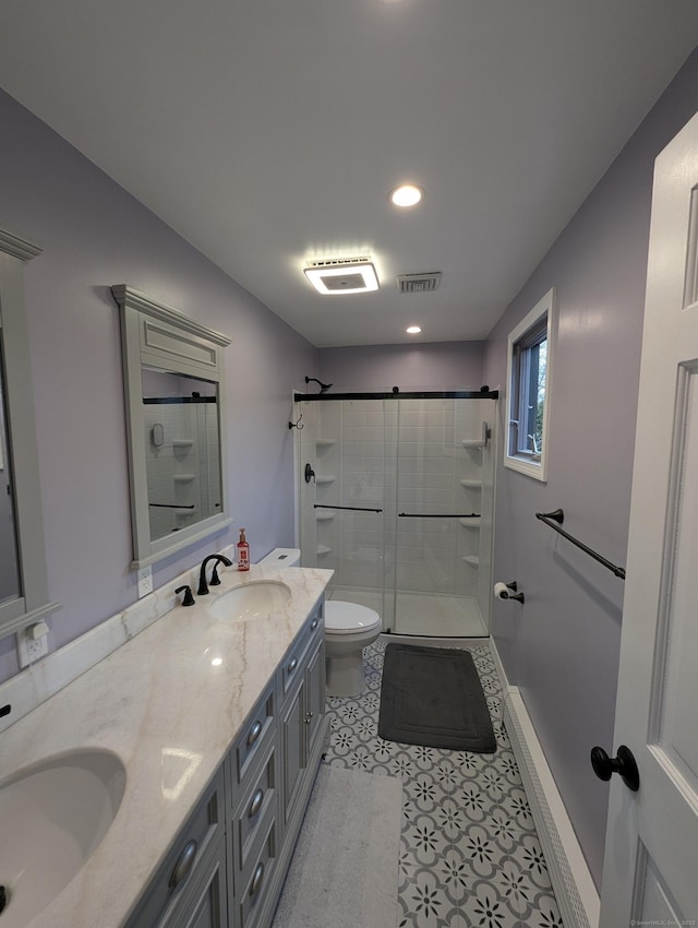 bathroom with a shower with shower door, vanity, tile patterned flooring, and toilet