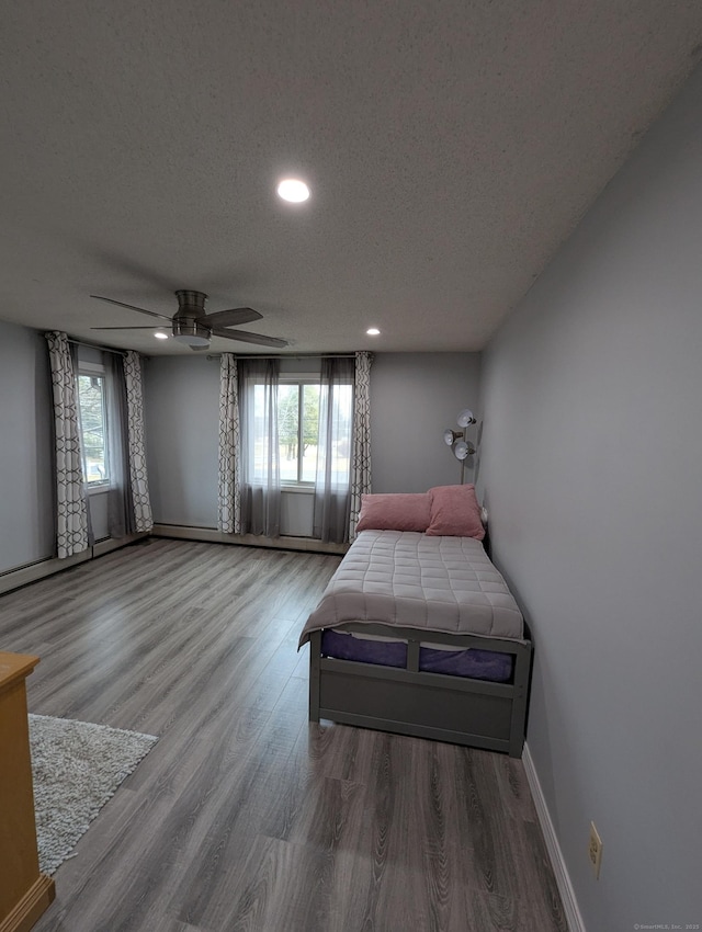 bedroom featuring ceiling fan, a textured ceiling, and wood-type flooring