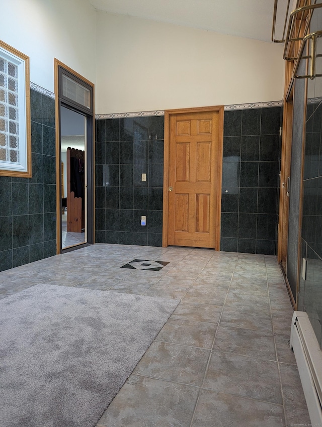 bathroom with a baseboard radiator, tile walls, and lofted ceiling