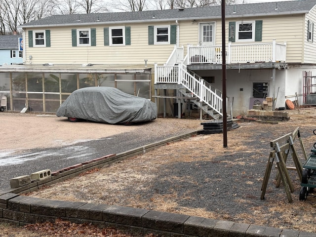 rear view of property with a wooden deck and a sunroom