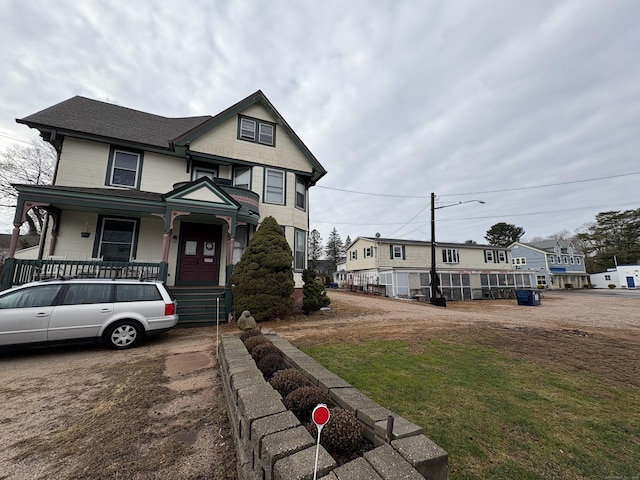 victorian home with covered porch and a front lawn