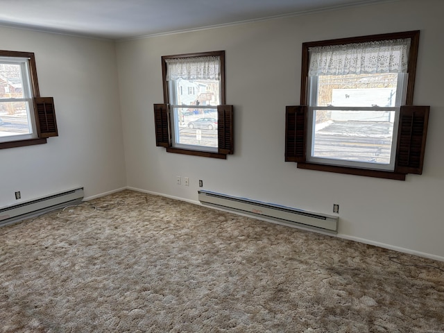 carpeted empty room featuring baseboard heating and crown molding