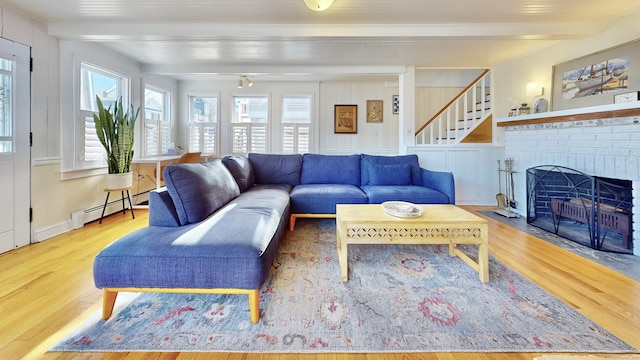 living room featuring a brick fireplace, baseboard heating, hardwood / wood-style floors, and beamed ceiling