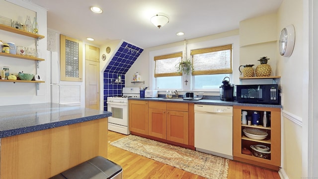 kitchen with sink, white appliances, light hardwood / wood-style flooring, and tasteful backsplash