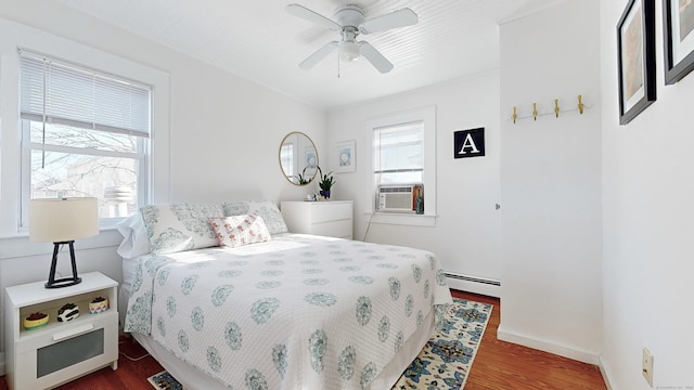 bedroom with ceiling fan, baseboard heating, cooling unit, and dark hardwood / wood-style floors