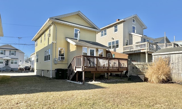 rear view of property with a deck and a yard