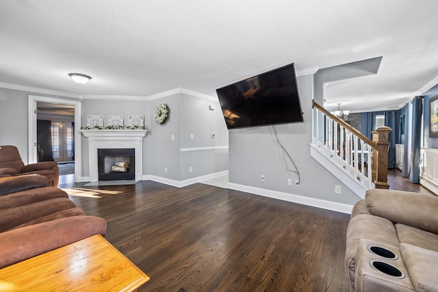 living room with ornamental molding, dark hardwood / wood-style flooring, a textured ceiling, and a notable chandelier