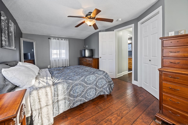 bedroom featuring lofted ceiling, dark hardwood / wood-style flooring, ceiling fan, a textured ceiling, and a closet