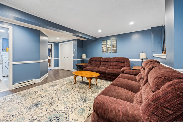 living room with ornamental molding, washer / dryer, a baseboard heating unit, and dark hardwood / wood-style floors