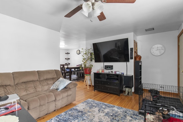 living room featuring ceiling fan and light hardwood / wood-style floors