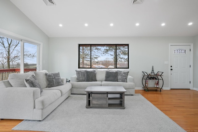 living room featuring vaulted ceiling and light wood-type flooring