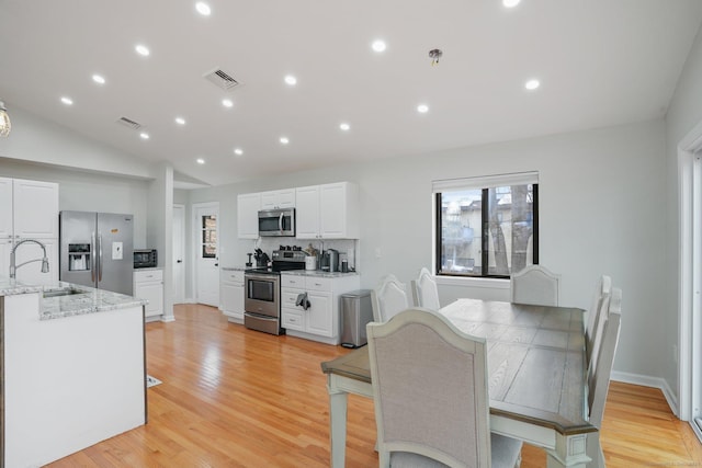 12 Willowledge Cir, Waterbury, CT 06704 - dining room with lofted ceiling, sink, and light hardwood / wood-style floors