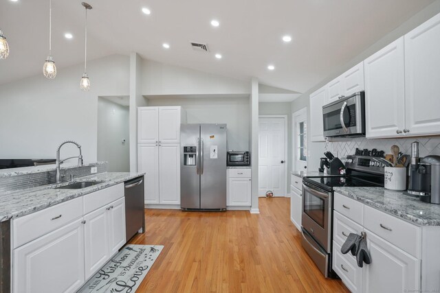 12 Willowledge Cir, Waterbury, CT 06704 - kitchen with vaulted ceiling, tasteful backsplash, white cabinetry, sink, and stainless steel appliances