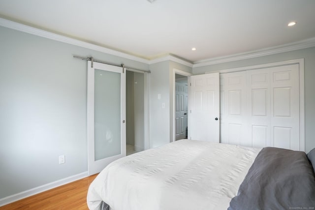 12 Willowledge Cir, Waterbury, CT 06704 - bedroom with ornamental molding, light hardwood / wood-style floors, a closet, and a barn door