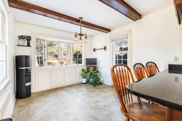 dining area featuring a chandelier, ornamental molding, beamed ceiling, and baseboards