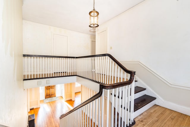 stairway with baseboards and hardwood / wood-style flooring