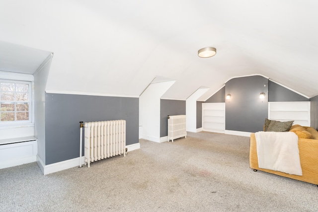 bonus room with radiator, carpet, built in shelves, and baseboards